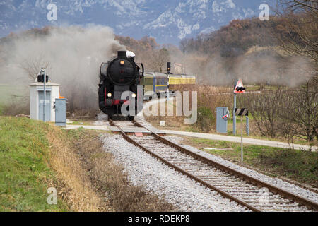 Vieux train à vapeur quittant la gare à Ajdovščina, la Slovénie, l'Europe. Beaucoup de noir et gris de la locomotive à vapeur se cacher, full frame Banque D'Images