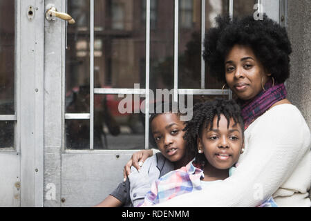 African American mother avec les enfants assis à l'extérieur smiling Banque D'Images