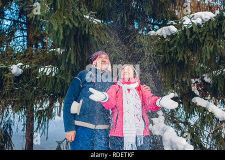 Woman throwing snow in winter forest. L'homme et la femme s'amuser le jour de la Saint-Valentin à l'extérieur Banque D'Images