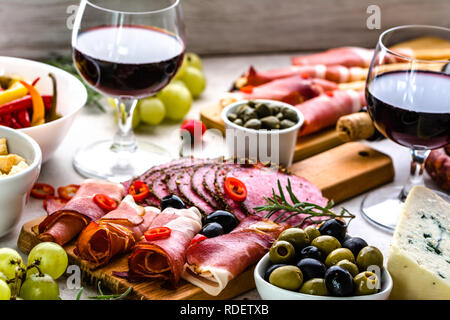 Sélection de l'alimentation, snack-vin situé sur table, antipasti italiens, jambon, salami, fromage, olives et autres amuse-gueule sur le plateau Banque D'Images