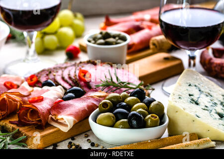 Variété de la nourriture sur la table, du vin, des olives, des en-cas et d'autres fromages apéritif, antipasti italiens sur la plaque Banque D'Images