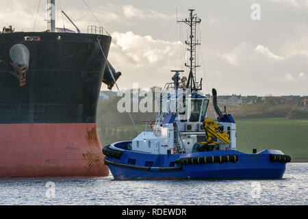 Une photo d'un cargo venant dans le port il est remorqué par un remorqueur Banque D'Images