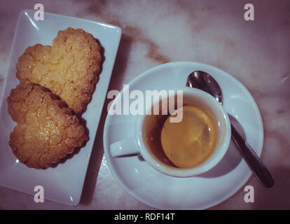 Coeur des cookies avec tasse de café dans un vrai café Banque D'Images