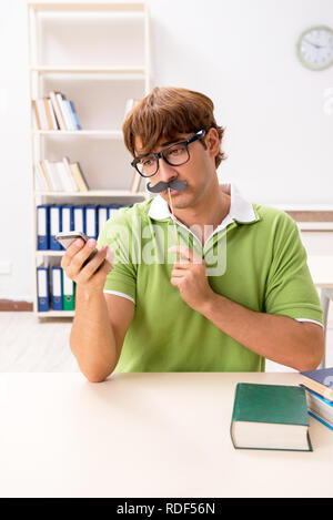 Étudiant avec fake moustache reading book Banque D'Images