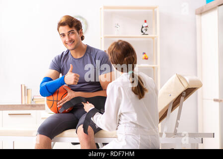 Beau joueur de basket-ball féminin en visite médecin traumatologist Banque D'Images