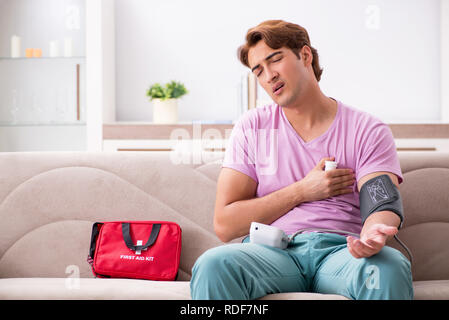 Homme malade à la maison avec une trousse de premiers secours Banque D'Images