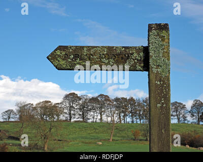 Lichen à peine lisibles traditionnelle incrustée fingerpost signe pour un sentier public en Cumbria, Angleterre, RU, un signe d'air non pollué Banque D'Images