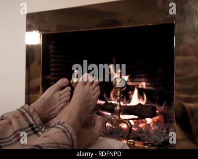 Close up image de couple sous la couverture par cheminée réchauffe pieds de cabin home dans les vacances d'hiver froid à happy moments romantiques Banque D'Images