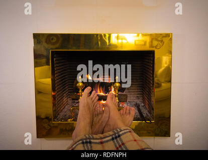 Close up image de couple sous la couverture par cheminée réchauffe pieds de cabin home dans les vacances d'hiver froid à happy moments romantiques Banque D'Images