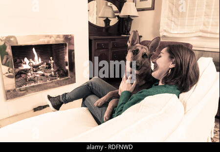 Magnifique portrait of smiling woman hugging son chien berger allemand ensemble devant le foyer à l'accueil chaleureux dans la journée d'hiver de bonheur l'Amitié Banque D'Images