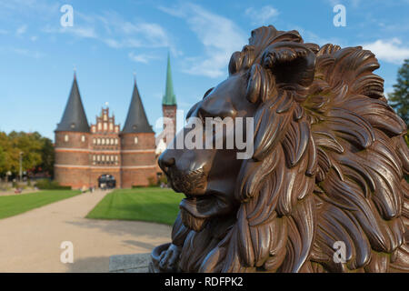 Lion statue en face de l'Holstentor/ Porte de Holstein dans la ville hanséatique de Lübeck, Schleswig-Holstein, Allemagne Banque D'Images