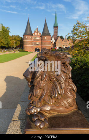 Lion statue en face de l'Holstentor/ Porte de Holstein dans la ville hanséatique de Lübeck, Schleswig-Holstein, Allemagne Banque D'Images