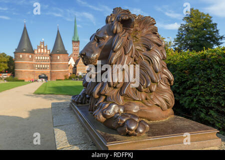 Lion statue en face de l'Holstentor/ Porte de Holstein dans la ville hanséatique de Lübeck, Schleswig-Holstein, Allemagne Banque D'Images