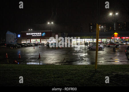 Toronto, Canada - Décembre 4th, 2019 : Dramatique nuit pluvieuse avec des rues désertes et tenant compte des feux de circulation par un magasin lumineux Banque D'Images