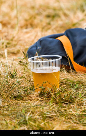 Gobelet plastique jetable de bière jetées sur l'herbe à un événement en plein air Banque D'Images