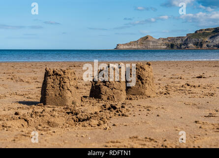 11châteaux sur la plage des Sables bitumineux, Runswick North Yorkshire, Angleterre Royaume-uni - Kettleness avec en arrière-plan Banque D'Images