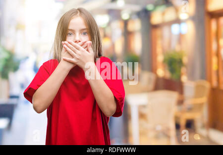 Belle jeune fille sur fond isolé choqué couvrant la bouche avec les mains pour l'erreur. Concept Secret. Banque D'Images