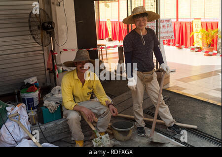 15.03.2018, Singapour, République de Singapour - Deux travailleurs migrants chinois sont de prendre une pause du travail dans le centre-ville. Banque D'Images