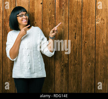 Beau young african american woman wearing glasses sur fond isolé en souriant et regardant la caméra pointant à deux mains et doigts Banque D'Images