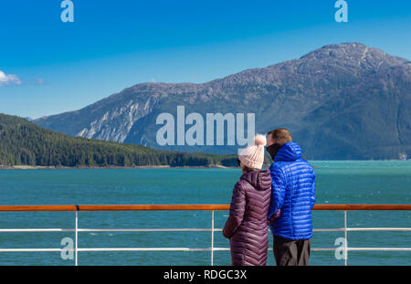 14 septembre 2018 - Le passage de l'Intérieur, de l'Alaska : chaudement vêtus young casual croisiéristes appréciant la vue ensoleillée près de Taku Inlet, au sud de Juneau. Banque D'Images