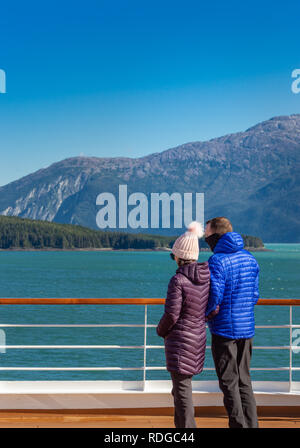 14 septembre 2018 - Le passage de l'Intérieur, de l'Alaska : chaudement vêtus young casual croisiéristes appréciant la vue ensoleillée près de Taku Inlet, au sud de Juneau. Banque D'Images