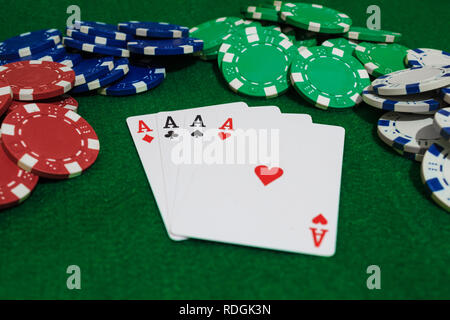 Main de poker, quatre as et jetons sur un fond vert. Vue en perspective. Banque D'Images
