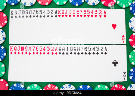 Des jeux de cartes, 13 rangs dans chacune des quatre couleurs, trèfle, carreau, cœur et pique. Châssis de jetons colorés sur zone verte Banque D'Images