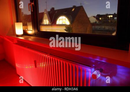 Radiateur à une fenêtre avec un thermostat, les coûts de chauffage Banque D'Images