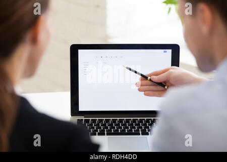 Serious businessman and businesswoman using laptop, maquette blanche Banque D'Images