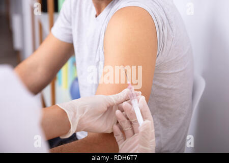 Close-up of a main du médecin du patient par injection avec seringue Banque D'Images