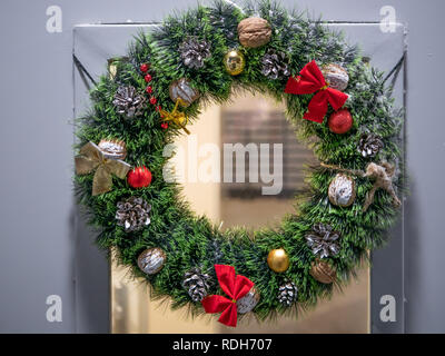 Libre de porte avant avec couronne de Noël faite de branches de pins, pommes de pin, les noix, et les bosses Banque D'Images