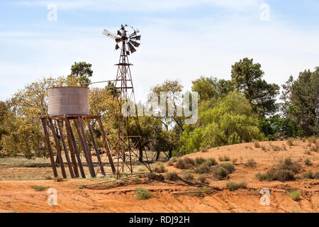 Vieux, abandonnés et oubliés, le moulin ne tourne plus et le réservoir d'eau se penche un peu plus près de la terre chaque année presque totalement effondré. Banque D'Images