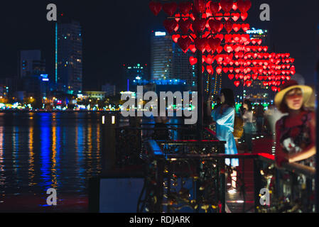 Da nang, Vietnam - 9 novembre 2018 : Pont d'amour et ses visiteurs dans la nuit illuminée de coeurs rouges de lampadaires et de la rivière. Banque D'Images