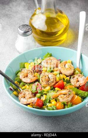 Avec salade de maïs, crevettes frites, tomates cerises, oignons rouges et la laitue en plaque bleue délicieux déjeuner frais, des aliments sains Banque D'Images