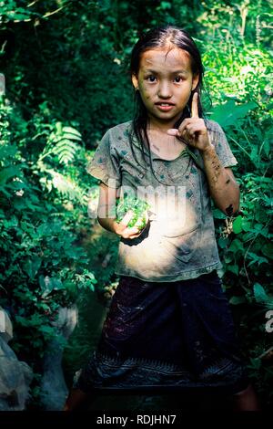 Luang Namta / Laos - 06 juil 2011 : cute young girl avec quelques légumes qu'elle a ramassés dans le jardin familial Banque D'Images