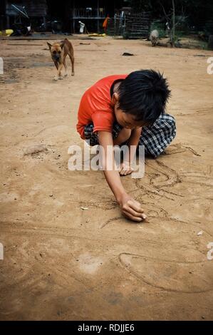 Paksong / Laos - 06 juil 2011 : jeune bouddhiste de dessin d'art et des symboles dans le sable Banque D'Images