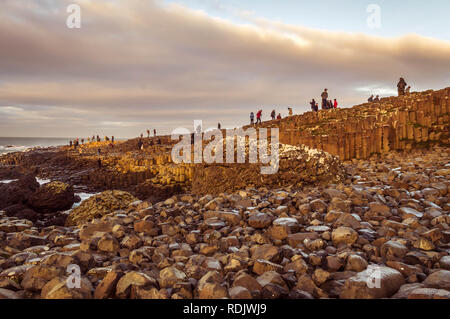 Le comté d'Antrim, Irlande du Nord, Royaume-Uni - Mai 28, 2016 : les touristes explorant à travers les grandes roches basaltiques de forme hexagonale à colonnes le comté d'Antrim, au nord Banque D'Images