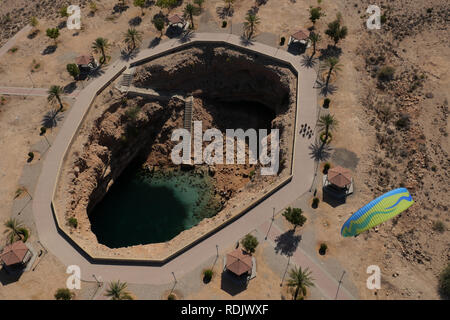Pilote paramoteur survolant Bimmah Sinkhole sur un paramoteur motorisé. en Oman. Banque D'Images