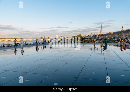 Bordeaux, France - Juillet 22, 2018 : les personnes bénéficiant de l'eau sur le miroir. Situé en face de la Place de la Bourse, cette piscine alterne un effet miroir un Banque D'Images