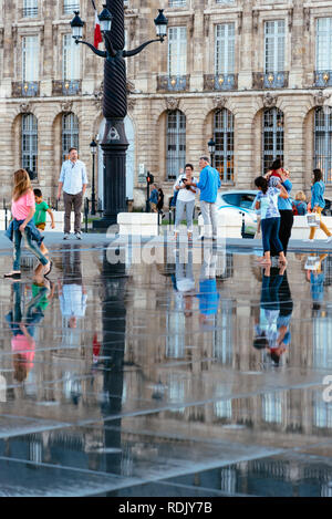 Bordeaux, France - Juillet 22, 2018 : les personnes bénéficiant de l'eau sur le miroir. Situé en face de la Place de la Bourse, cette piscine alterne un effet miroir un Banque D'Images