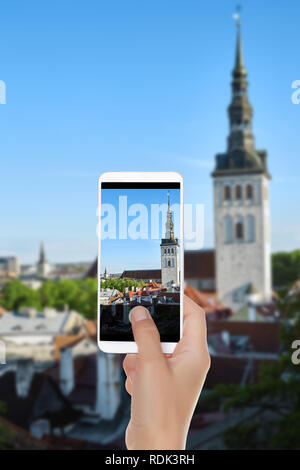 Un homme fait une photo de rue de la vieille ville sur une journée ensoleillée à Tallinn, Estonie sur un téléphone mobile Banque D'Images