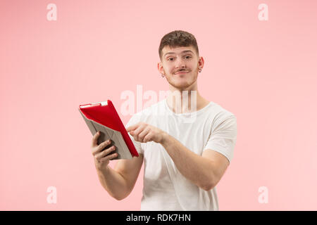 Portrait of smiling man pointing at laptop avec écran blanc isolé sur fond rose studio. Les émotions humaines, l'expression faciale concept et concept de publicité. Banque D'Images