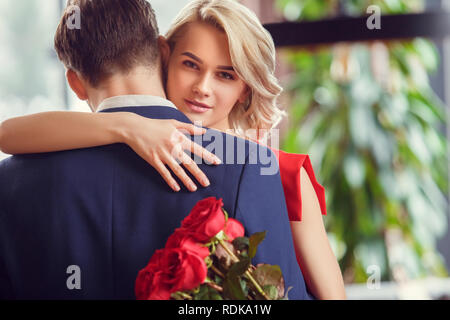 Jeune couple sur la date dans le dancing holding bouquet Banque D'Images