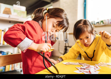 Les enfants atteints du syndrome de Down montrant leurs langues jouant Banque D'Images