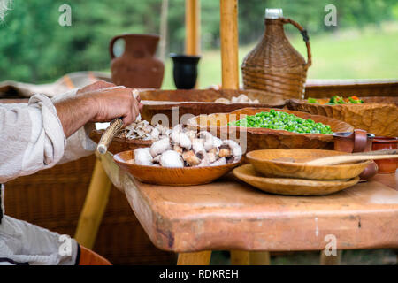 Mans mains champignons blancs nettoyage avant de préparer le repas. Les plaques en bois, table en bois Banque D'Images