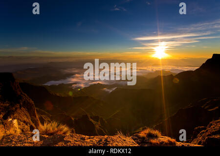 Camping des randonneurs sur le dessus de l'Amphithéâtre dans le Drakensberg peut profiter d'un lever de soleil spectaculaire sur le Parc National Royal Natal d'un sommet vantage Banque D'Images