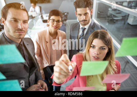 L'organisation de l'équipe d'affaires créatifs à sticky notes sur la fenêtre Banque D'Images