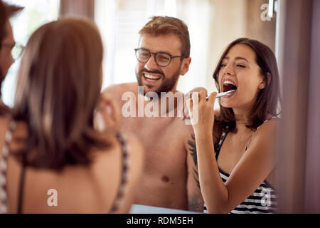 Beau couple se brosser les dents le matin à la salle de bains ensemble Banque D'Images