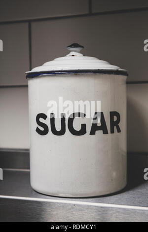 Close up of white vintage enamel tin sucre avec lettrage noir. Banque D'Images