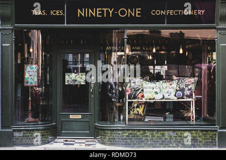 Vue extérieure de l'intérieur design store à imprimé floral vintage coussins sur banc métallique en vitrine. Banque D'Images